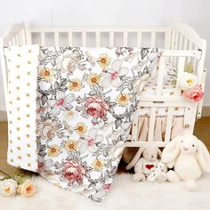 a white crib with flowers and stuffed animals next to it