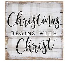 a wooden sign with the words christmas begins with christ on it, in black and white