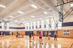 some people are playing basketball in a gym