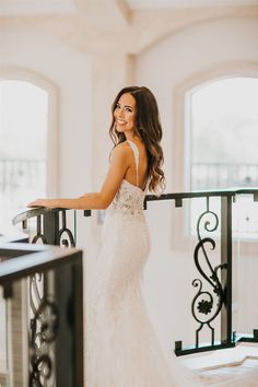 a woman in a wedding dress standing on a balcony