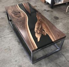 a coffee table made out of wood and metal frame with an artistic design on the top