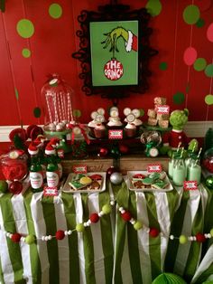 a christmas themed dessert table with green and white striped cloth, candy bar wrappers, cupcakes and candies