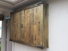 a wooden door hanging on the side of a building