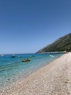 several boats floating in the water on a beach