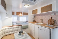 a kitchen area with sink, dishwasher and refrigerator freezer next to a bed