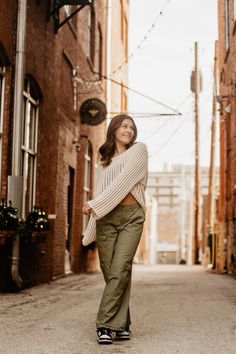 a woman is standing in an alley way