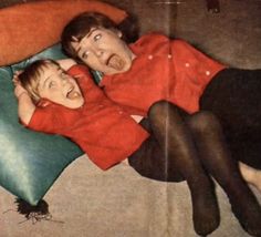 an old photo of two people laying on a pillow