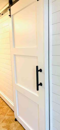 an open white barn door with black hardware