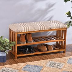 a wooden shoe rack sitting on top of a hard wood floor next to a potted plant