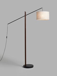 a lamp that is sitting on top of a table next to a light fixture with a white lampshade