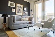 a living room filled with furniture and framed pictures on the wall above a coffee table