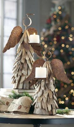 a candle holder made out of driftwood with angel wings on top and candles in the middle