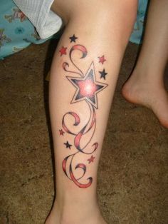 a woman's leg with stars and swirls tattoo on the side of her leg