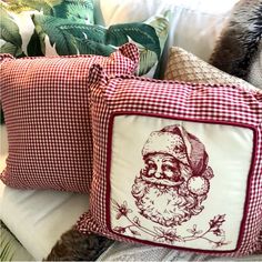 two christmas pillows with santa claus on them