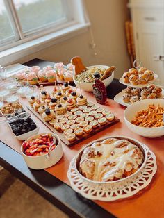 a table filled with lots of food and desserts