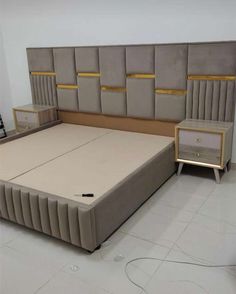 a bed with two nightstands and a headboard made out of upholstered fabric