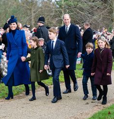 a group of people that are walking down a path together in coats and hats,