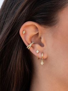 a woman wearing gold ear cuffs with diamonds