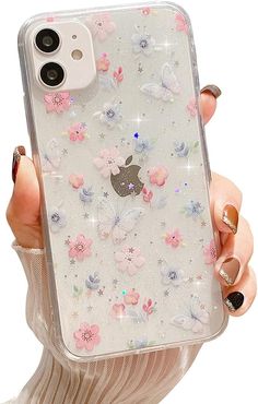 a woman holding an iphone case with flowers and butterflies on it