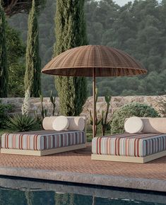 two chaise lounges with an umbrella next to a pool