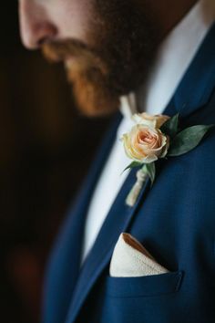 a man in a suit with a boutonniere and flower on his lapel