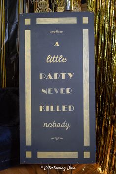 a little party never killed nobody sign in front of gold streamers and tinsel