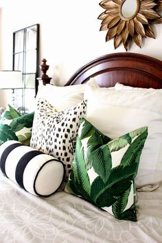 an image of a bed with pillows on it and a mirror above the headboard