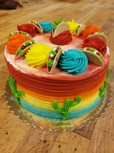 a colorful cake with frosting on top of a wooden table