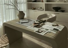 the table is covered with magazines and vases