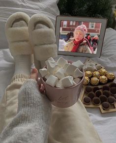 someone is holding a bowl of marshmallows in front of some chocolates