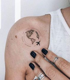 a woman's arm with a small world map tattoo on the left side of her arm