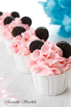 three cupcakes with pink frosting and mickey mouse ears