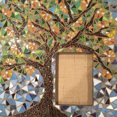 a tree made out of mosaic tiles with a photo frame