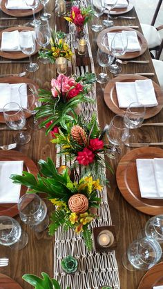 a long table is set with place settings and flowers