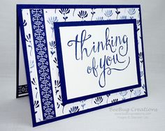 a blue and white greeting card with the words thinking of you