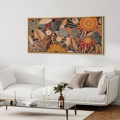 a living room filled with furniture and a painting on the wall above it's coffee table