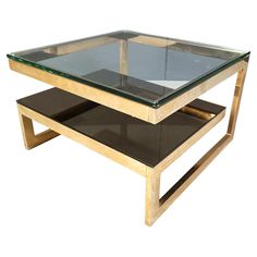 a glass and wood coffee table with two shelves on each side, against a white background