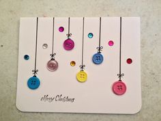 a christmas card with buttons hanging from strings