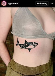 a woman's stomach with a shark tattoo on her belly and the words, following