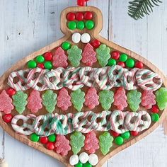 an ornament made out of candy canes and marshmallows on a wooden board