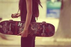 a woman holding a skateboard in her hands