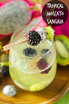 a tropical moscato sangria is garnished with blackberries and kiwi