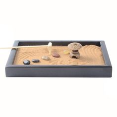 a sand tray with rocks and an object in it