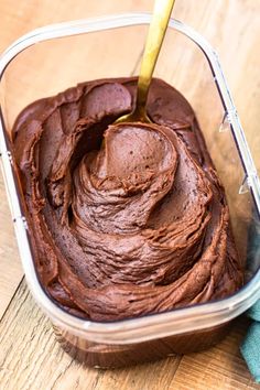 a container filled with chocolate frosting on top of a wooden table