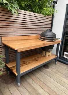 a wooden table sitting on top of a hard wood floor next to a planter