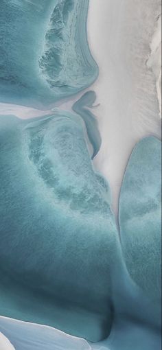 an aerial view of blue water and white sand