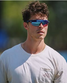 a man wearing sunglasses and a white shirt