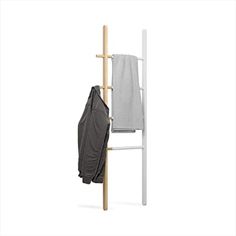 a coat rack with two coats hanging from it's sides and an umbrella on the other side