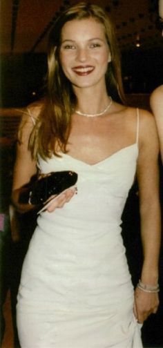 a woman in a white dress is smiling