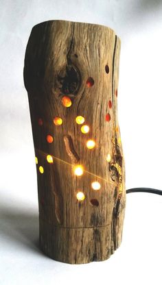 a wooden object with lights on it sitting on a white surface next to a cord